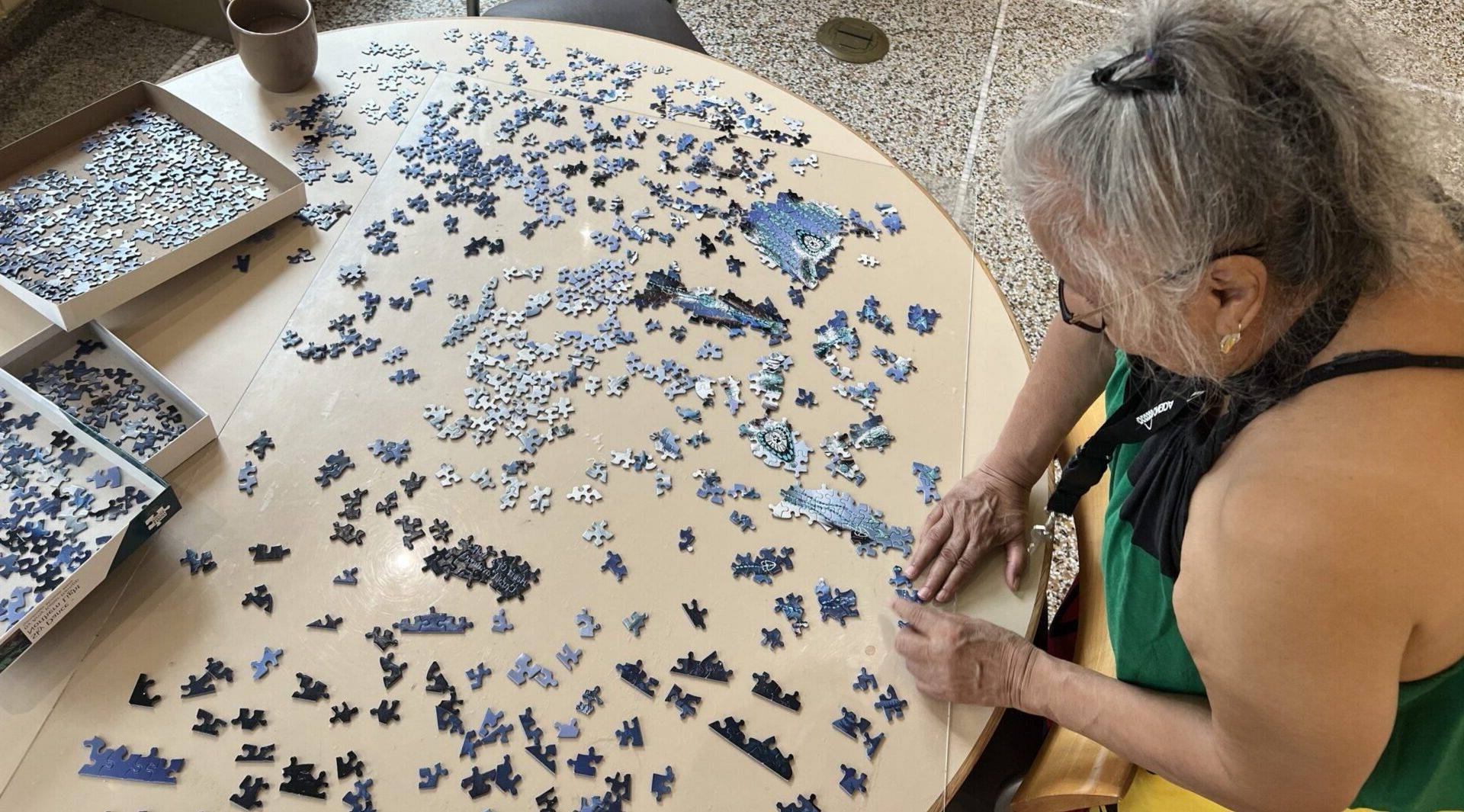 Woman working on a  puzzle on a table